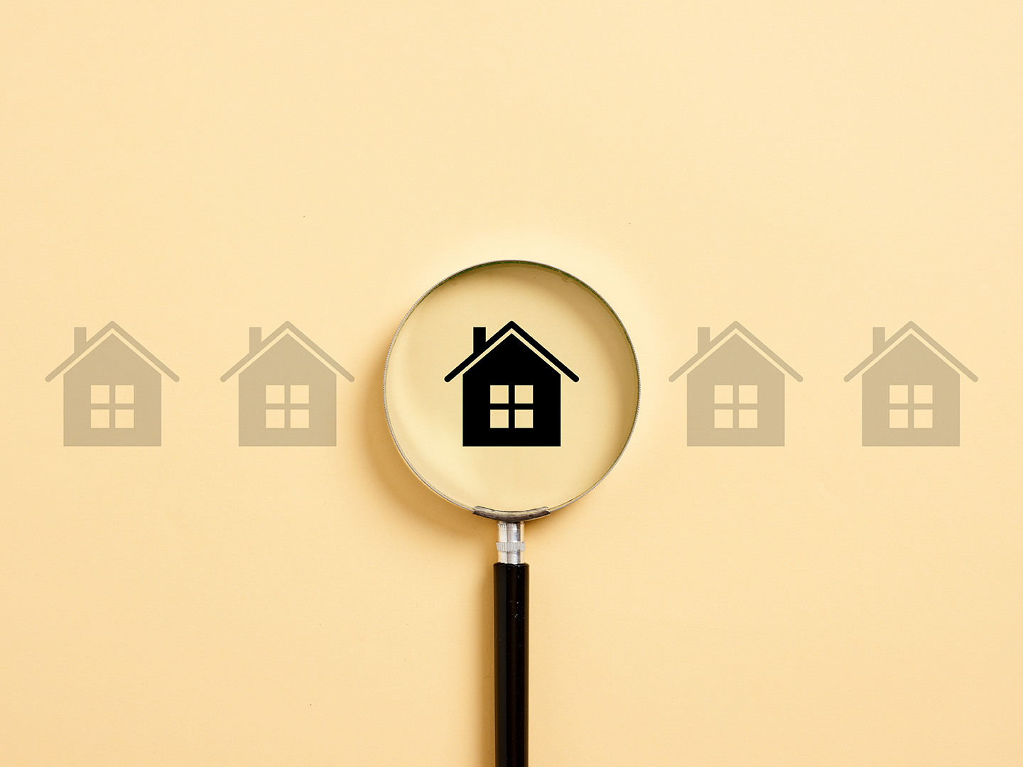 Magnifying glass focusing on a house icon, symbolizing property inspection before buying in Dubai